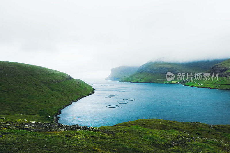 在夏季多云的日子在法罗群岛的海景和山的风景