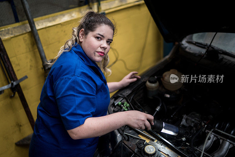 女技工在汽车修理厂工作的肖像