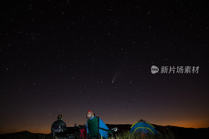 朋友露营和看星星和彗星在夜晚
