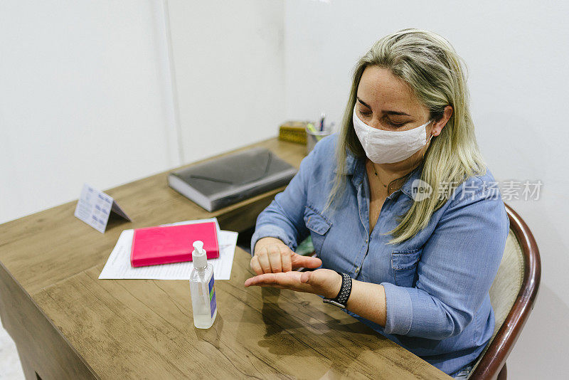 新常态:女性在办公室进行手部消毒