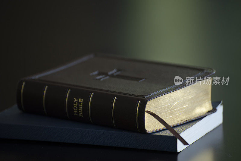 在教堂的黑色书桌上放置圣经和木制十字架，准备学习基督教圣经。