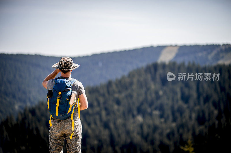 手持双筒望远镜观察风景的徒步旅行者