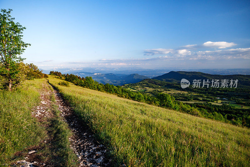 在春天的晚些时候，在法国阿尔卑斯山脉中部的山顶徒步旅行的土路