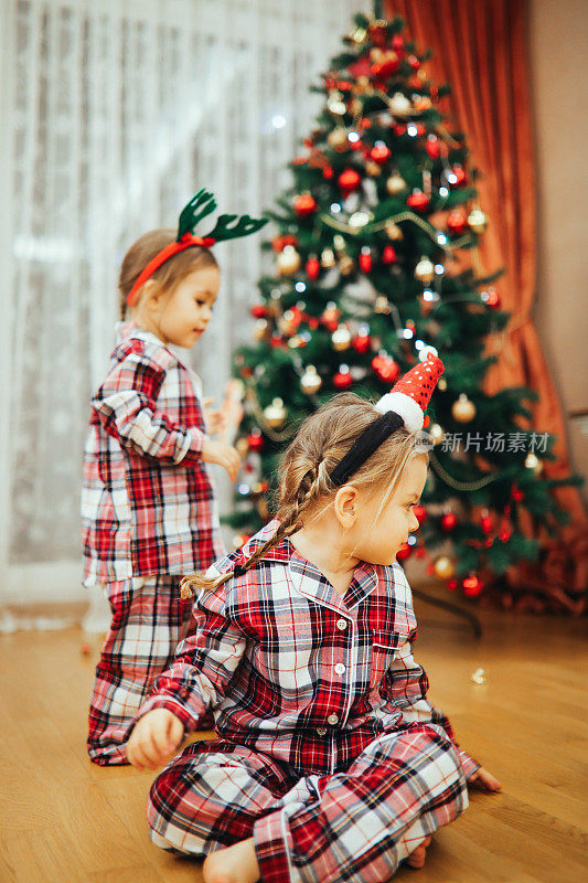 兄弟姐妹在家里圣诞树前拥抱的肖像