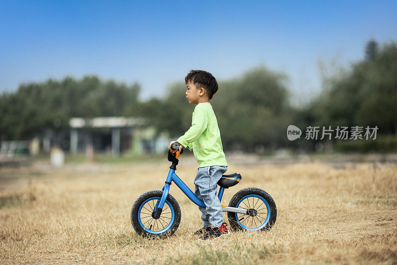 一个小男孩在户外学骑自行车