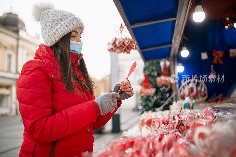 一个愉快的白人妇女在冬季假期买糖果的侧面
