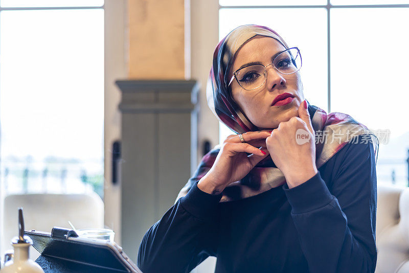 一名穆斯林妇女在餐馆里用药片喝茶
