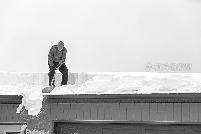 老人从屋顶上铲雪