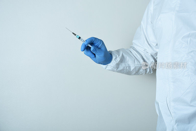 医生或护士手持医用注射针筒注射疫苗