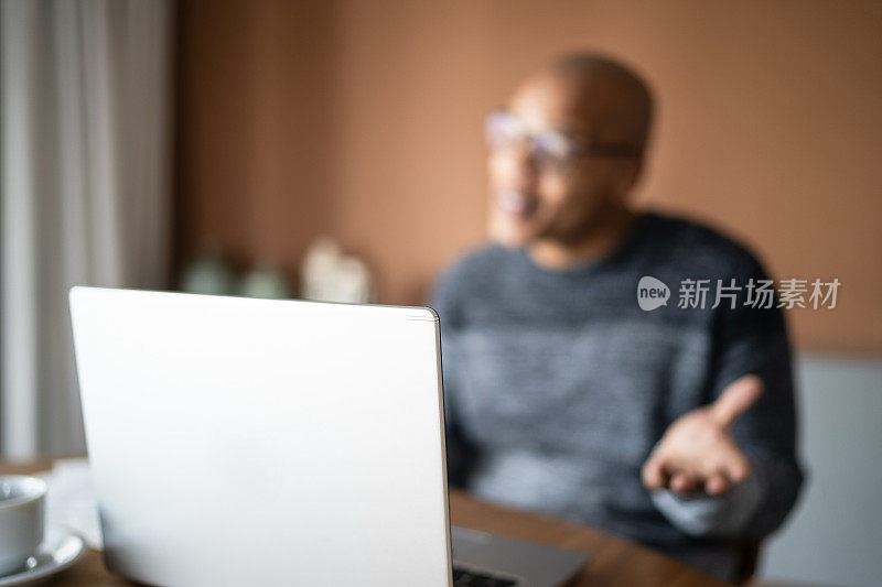 男人在家里用笔记本电脑打视频电话