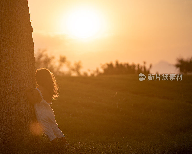 日落时分，女孩在公园里玩捉迷藏