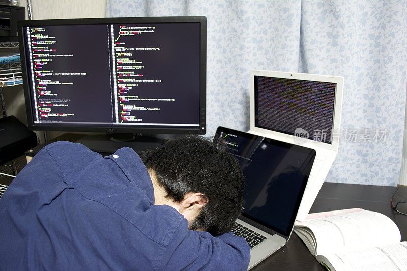 一个年轻的亚洲程序员在他的房间里编程的时候开始睡觉