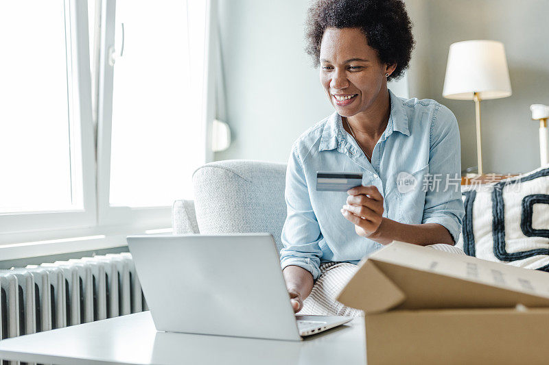 非洲裔美国女性在网上购物，用信用卡支付