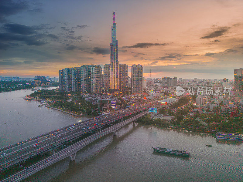 从空中俯瞰81号地标的日落景观——一幢超高的摩天大楼和西贡大桥，西贡河沿岸的发展在光线下十分流畅