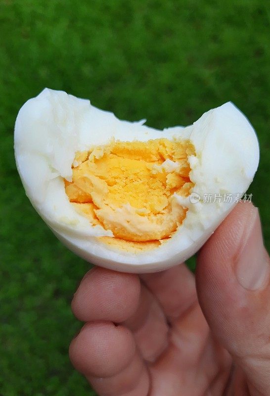 手握半熟的煮蛋。