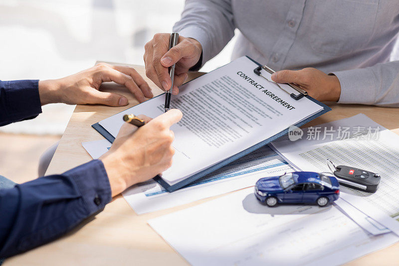 汽车保险文件或租赁概念，汽车经纪人协助他的客户，并解释汽车联系的细节。汽车钥匙买卖签约。