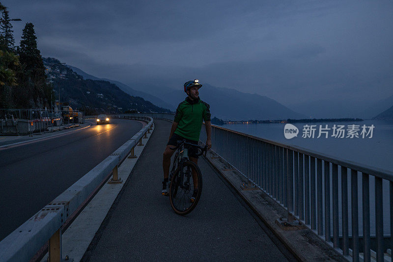 晚上骑自行车训练的男子在自行车道上休息