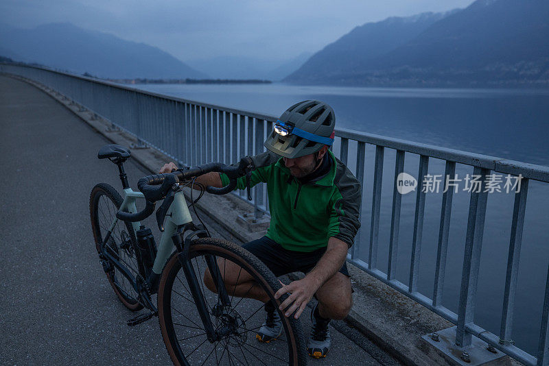 晚上骑自行车训练的男子在自行车道上休息