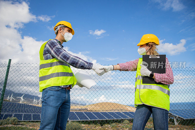 两个同事在太阳能发电厂工作时握手，达成协议的概念