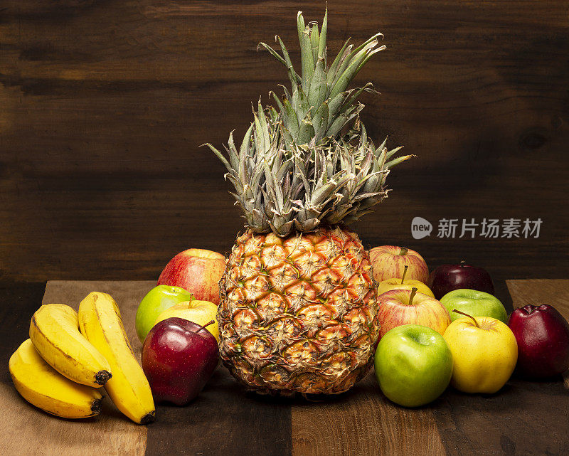 菠萝水果，香蕉和苹果水果在木制背景
