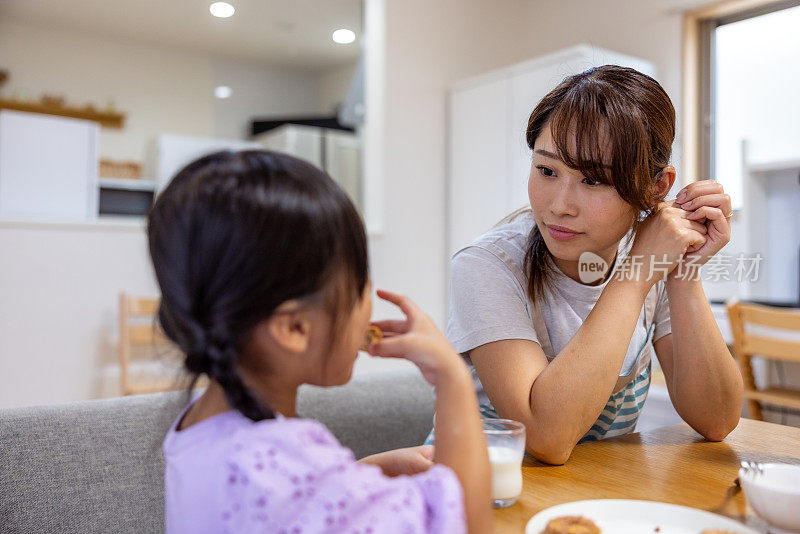 母女俩在家里吃着自制的饼干