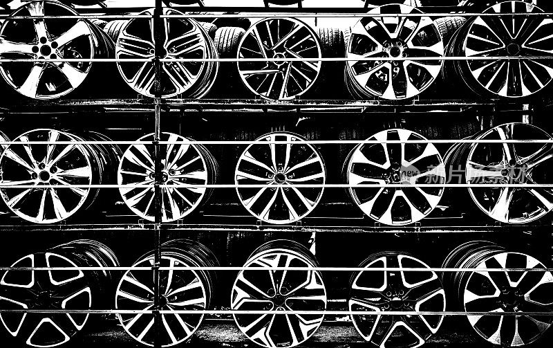 货架上展示的不锈钢汽车金属轮架，圆形金属物体的抽象形状和几何形状，单色照片