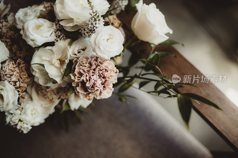 新娘婚礼花束的特写，花束上有奶油色和浅粉色的花
