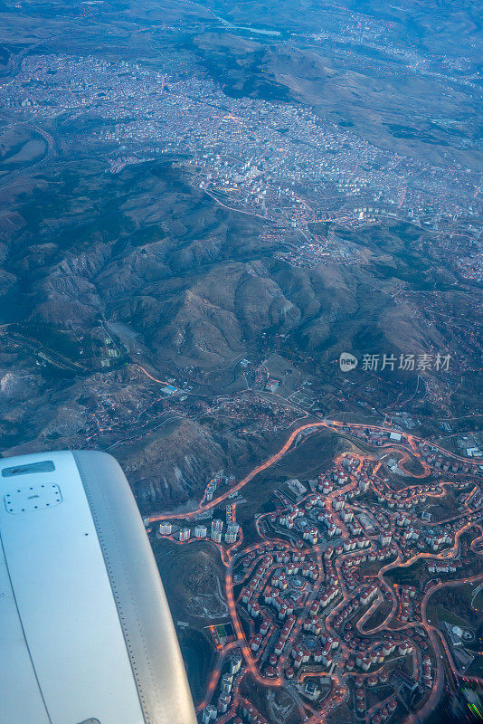 日落时分城市乘客的视角是飞机引擎仍在垂直空中飞行