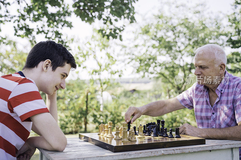 爷爷和孙子在一起下棋。