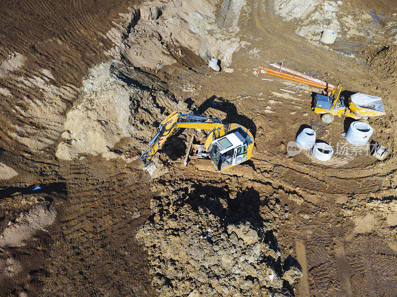 建筑工地鸟瞰图，挖掘机和机械在一个大的土坑里。