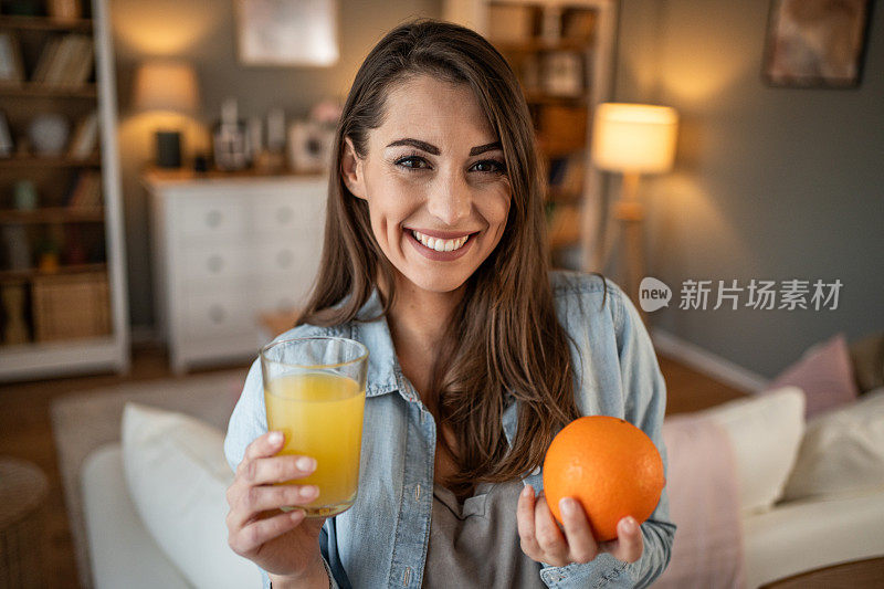 一位年轻女子享受着喝鲜橙汁的时刻