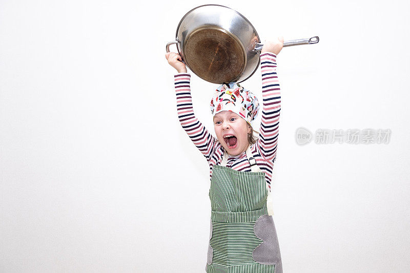 一个白人女孩，8岁，小厨师，手里拿着一个大煎锅，挥舞着煎锅，开心地笑着。在浅色背景上的肖像。