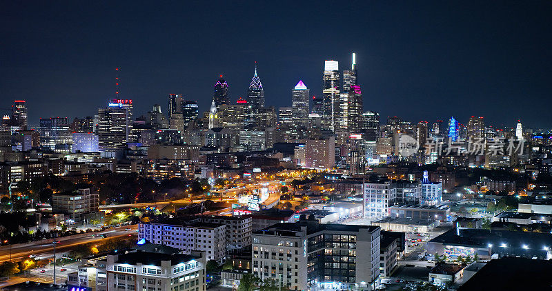 多云夜晚，费城市中心灯火通明的天际线