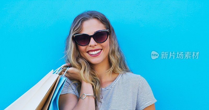 时尚，销售和女性肖像，在一个城市购物，从商店，商场或精品店蓝色背景的包。零售，折扣和面对女性顾客兴奋的促销，礼品或选择