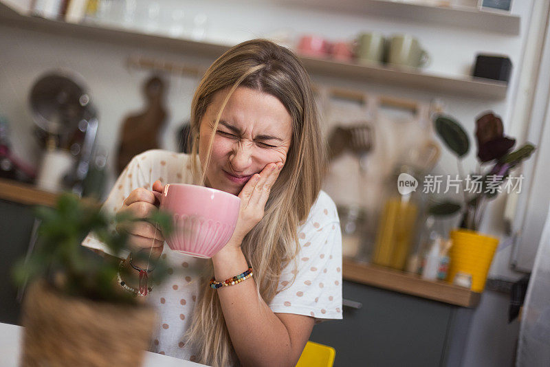 这个女人喝了一口热咖啡，感到牙齿一阵剧痛。牙釉质过敏和牙齿健康问题