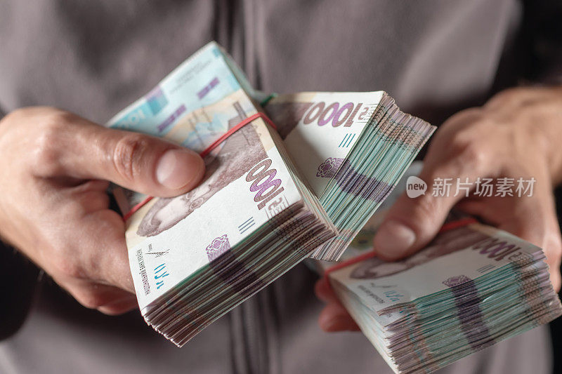 一名男子手持乌克兰货币1000格里夫纳纸币。特写镜头