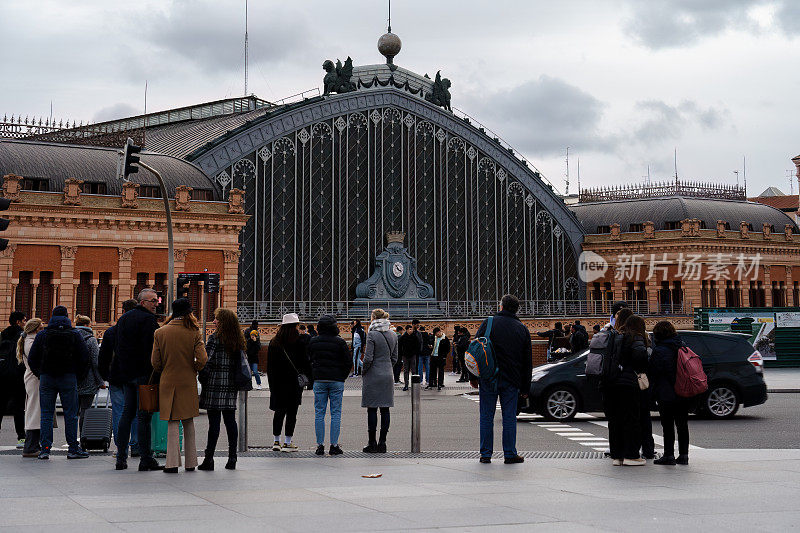 一群人站在西班牙马德里历史悠久的阿托查火车站前。