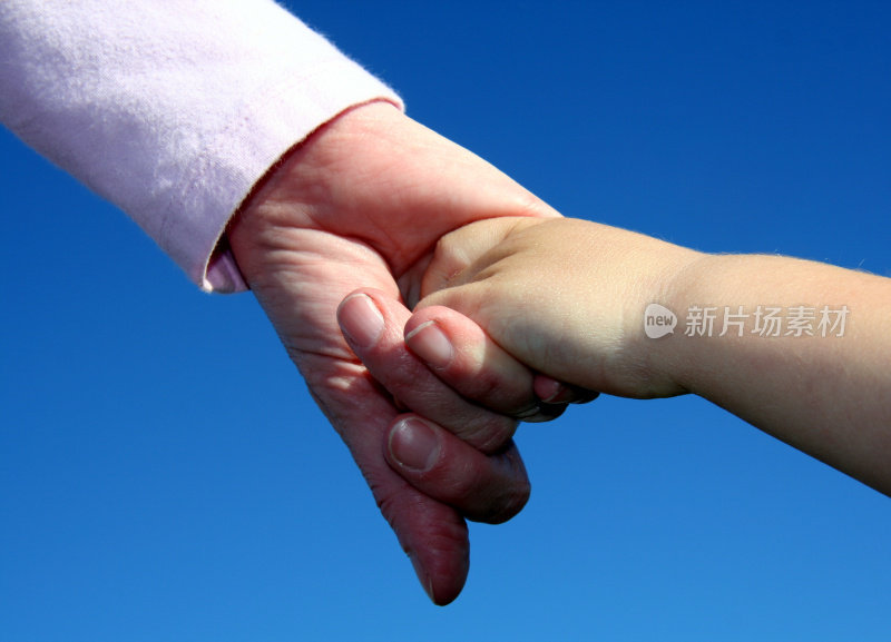 母亲和年幼的儿子牵着手在蓝色的背景