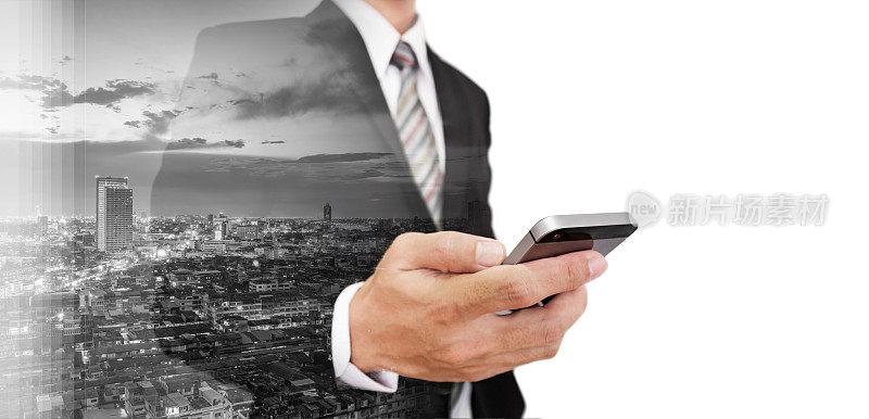 商人使用智能手机双重曝光摩天大楼的城市景观