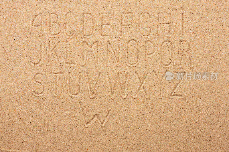 英语、德语、葡萄牙语字母写在沙滩上