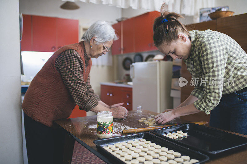 祖母和孙女烘烤饼干准备面团