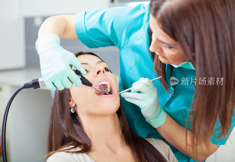 牙科医生为年轻女性病人做牙科手术
