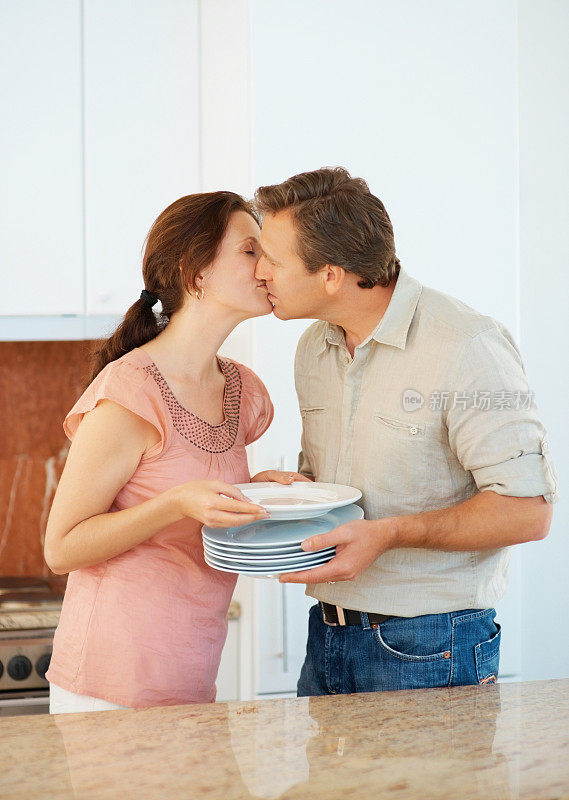 夫妻在做家务时在厨房接吻