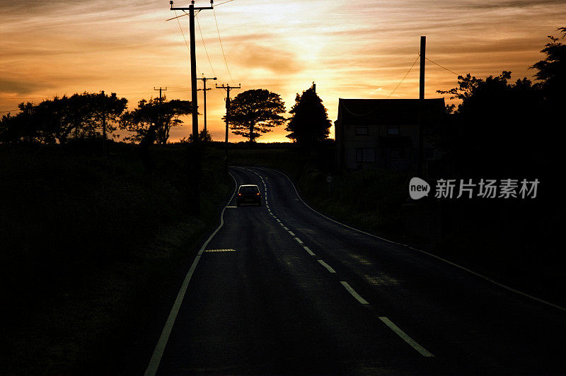 汽车在威尔士路上驶入夕阳