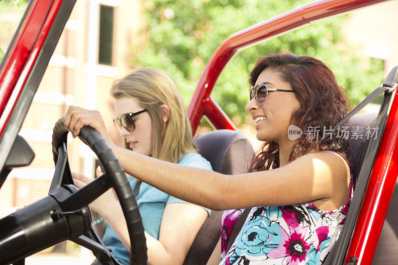 多民族少女进行夏季公路旅行。驾驶车辆。