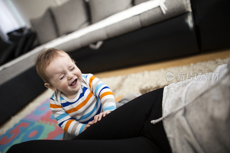 男婴(9个月)坐在地板上哭