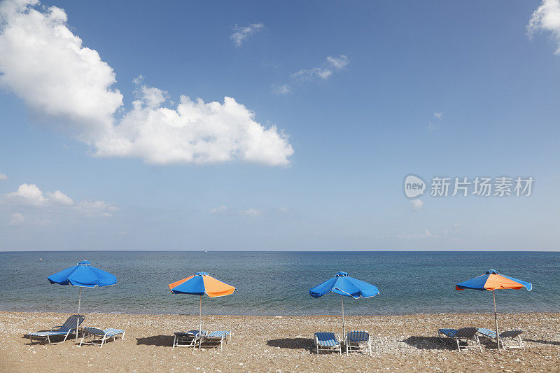 四排条纹日光浴床和雨伞塞浦路斯拉特西海滩