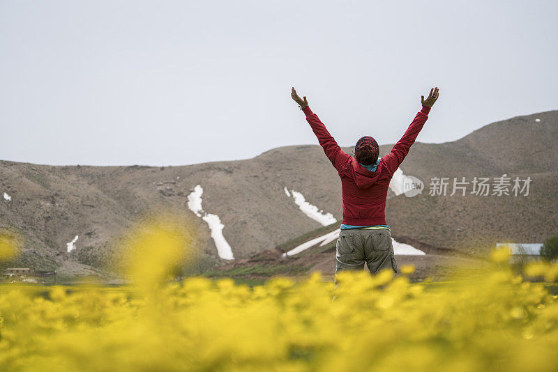 成熟女人在花园中张开双臂