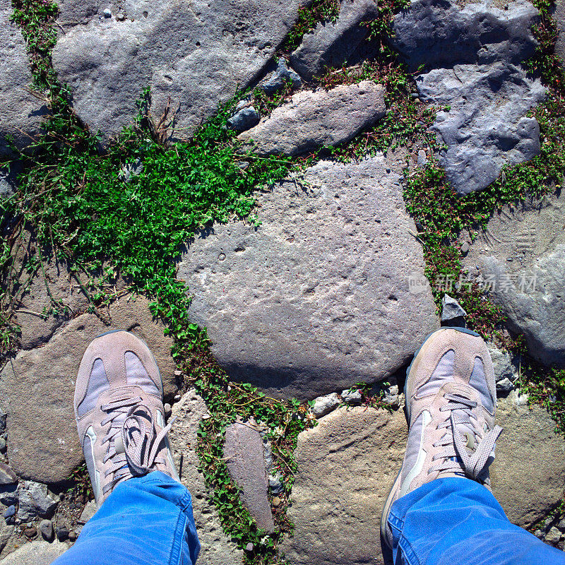 双脚踩在鹅卵石上。