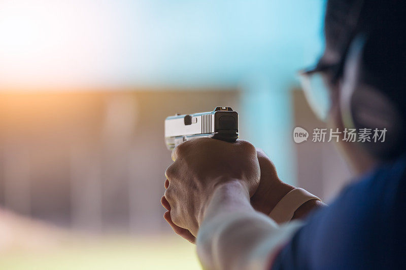 执法人员在学校射击场用双手瞄准手枪